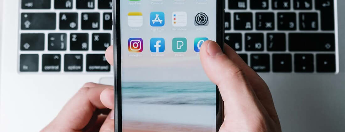 hand holding iphone tapping on social app